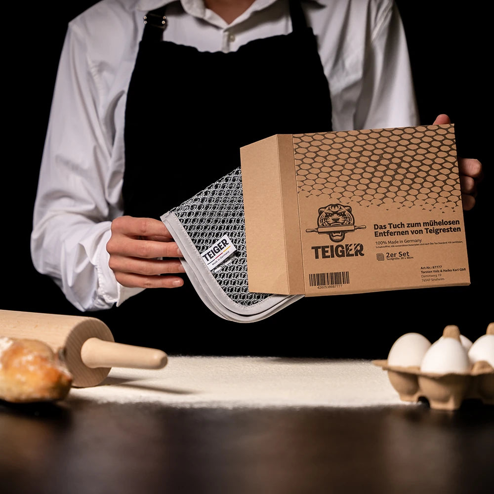 Ein Bäcker oder Bäckerin zeit das Tuch und die Verpackung dazu